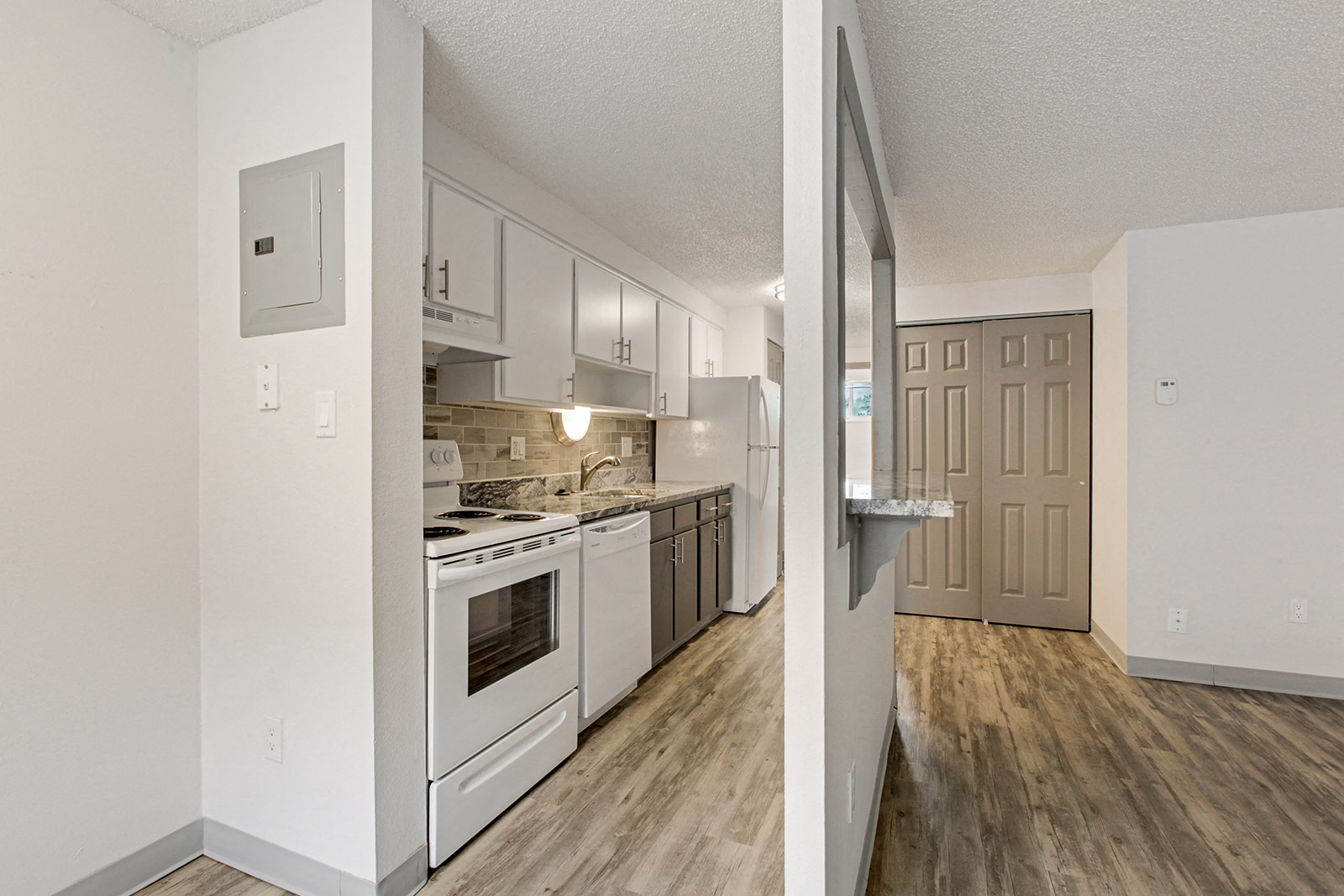 an empty kitchen with white appliances and white cabinets