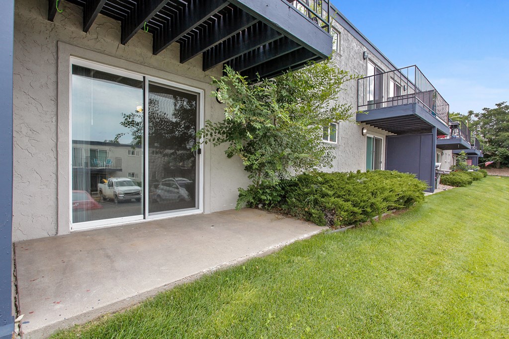 the side of a house with a patio and a glass door