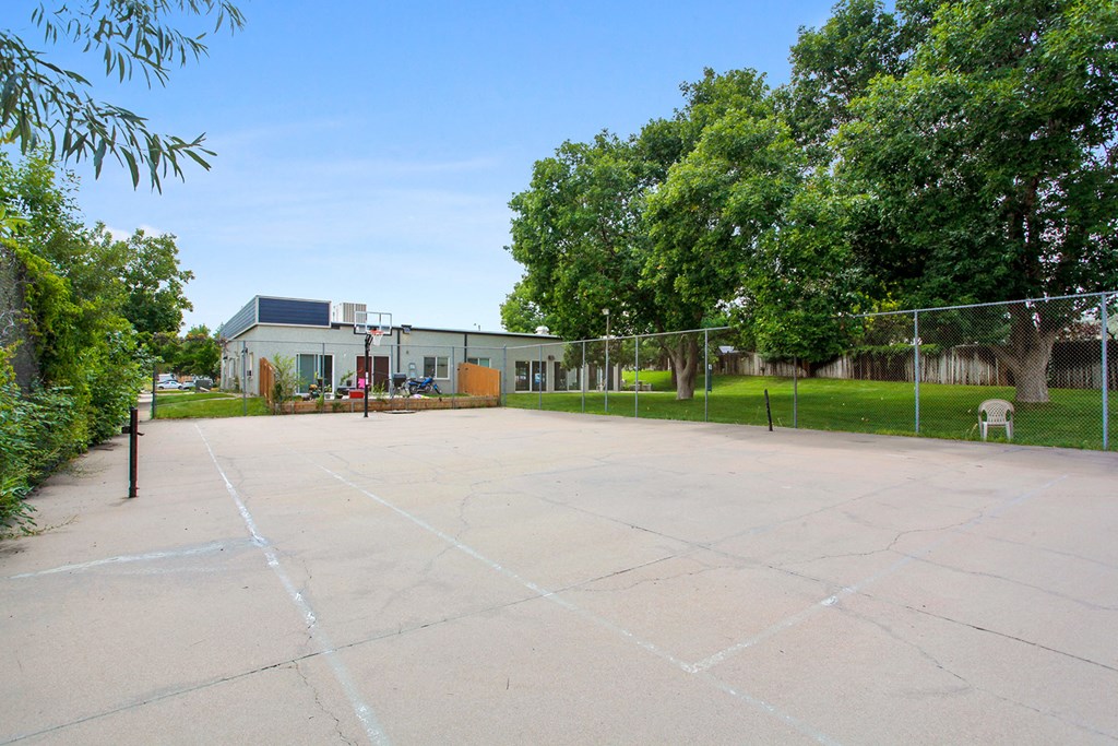 an empty basketball court with a building in the background