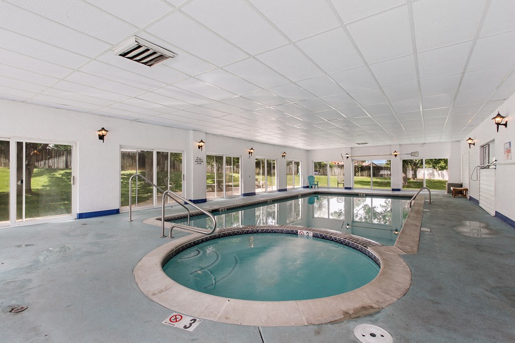 a indoor swimming pool with a tub in the middle of the floor