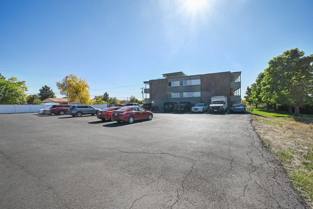 a parking lot with cars in front of a building