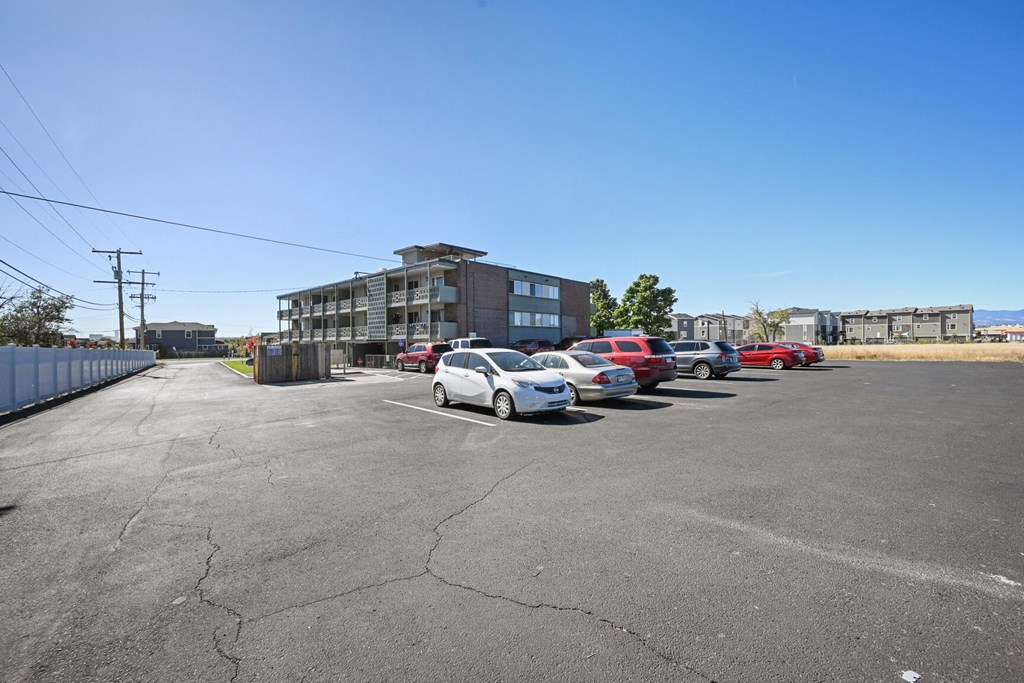 a parking lot with cars in front of a building