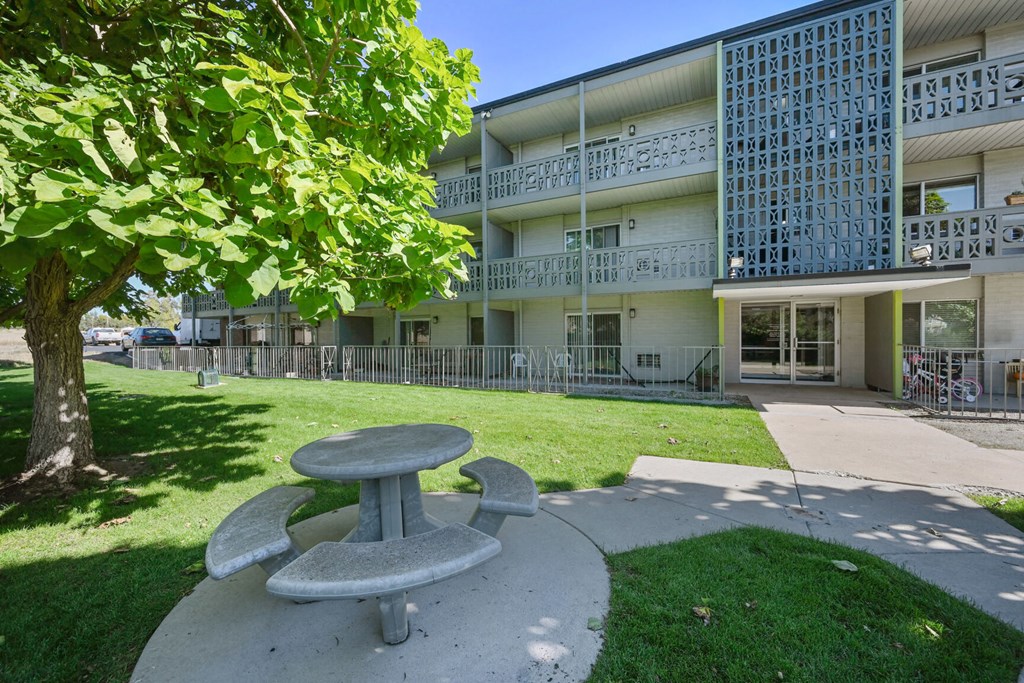 a picnic table in front of an apartment building