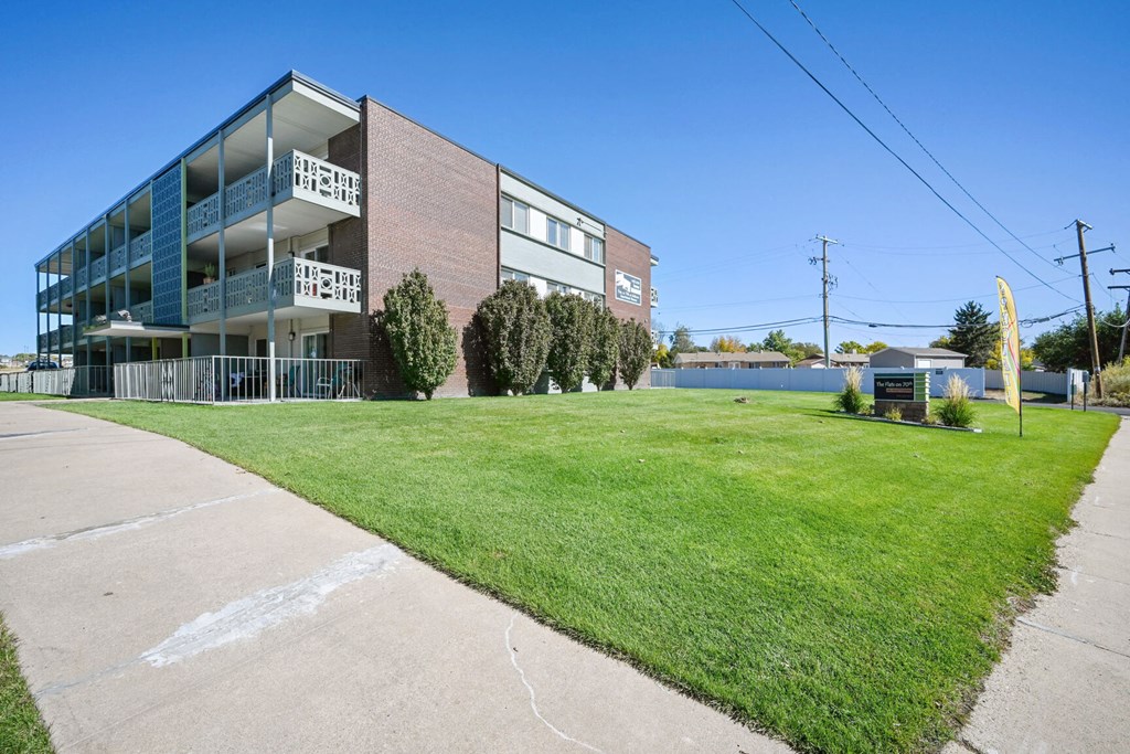 an apartment building with a lawn in front of it