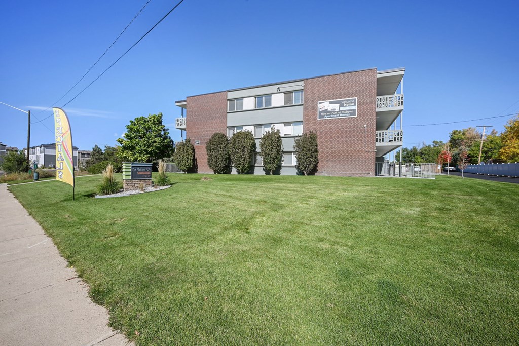 a large brick building with a lawn in front of it