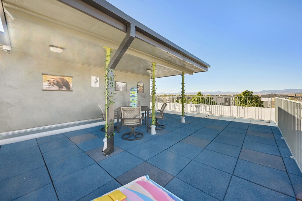 a patio with a table and chairs under a roof