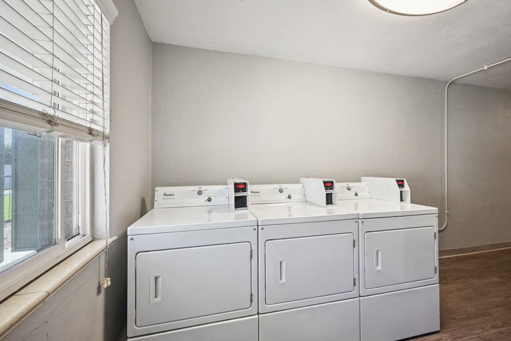 four washers and dryers in the laundry room of a home
