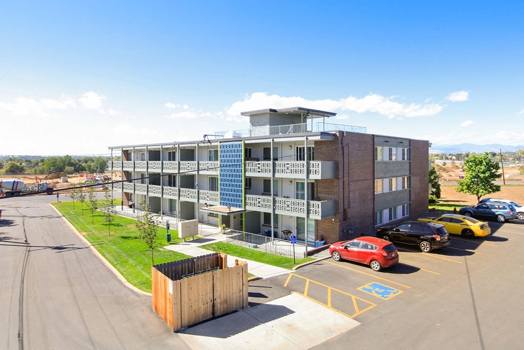 an apartment building with cars parked in front of it