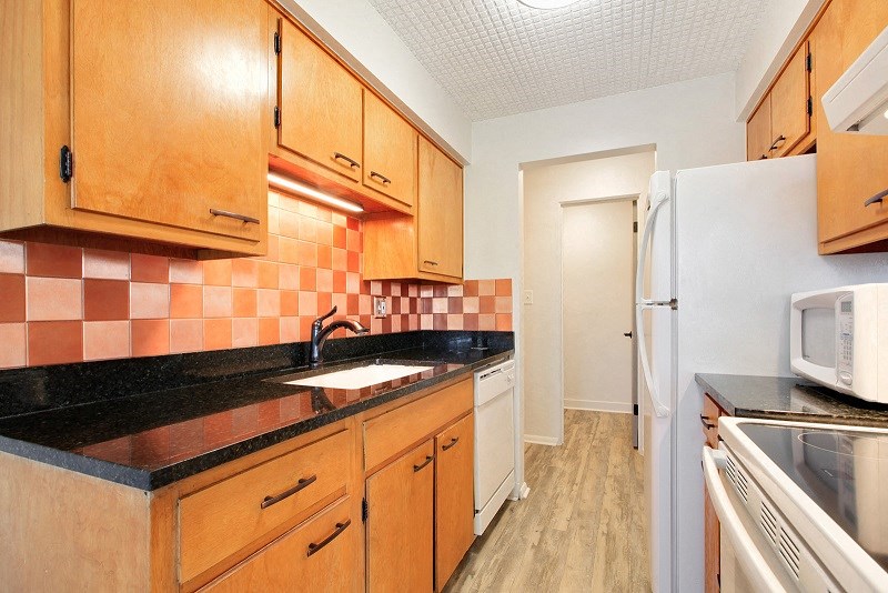 a kitchen with wooden cabinets and a sink and a refrigerator