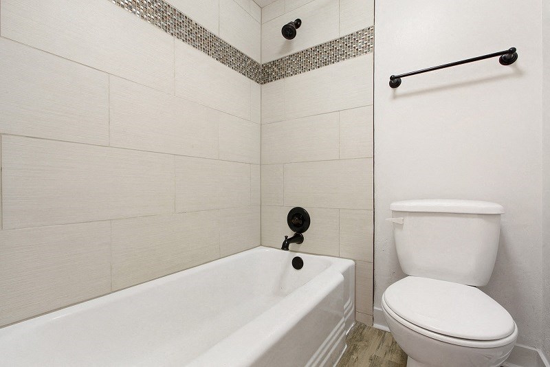 a white bathroom with a toilet and a tub