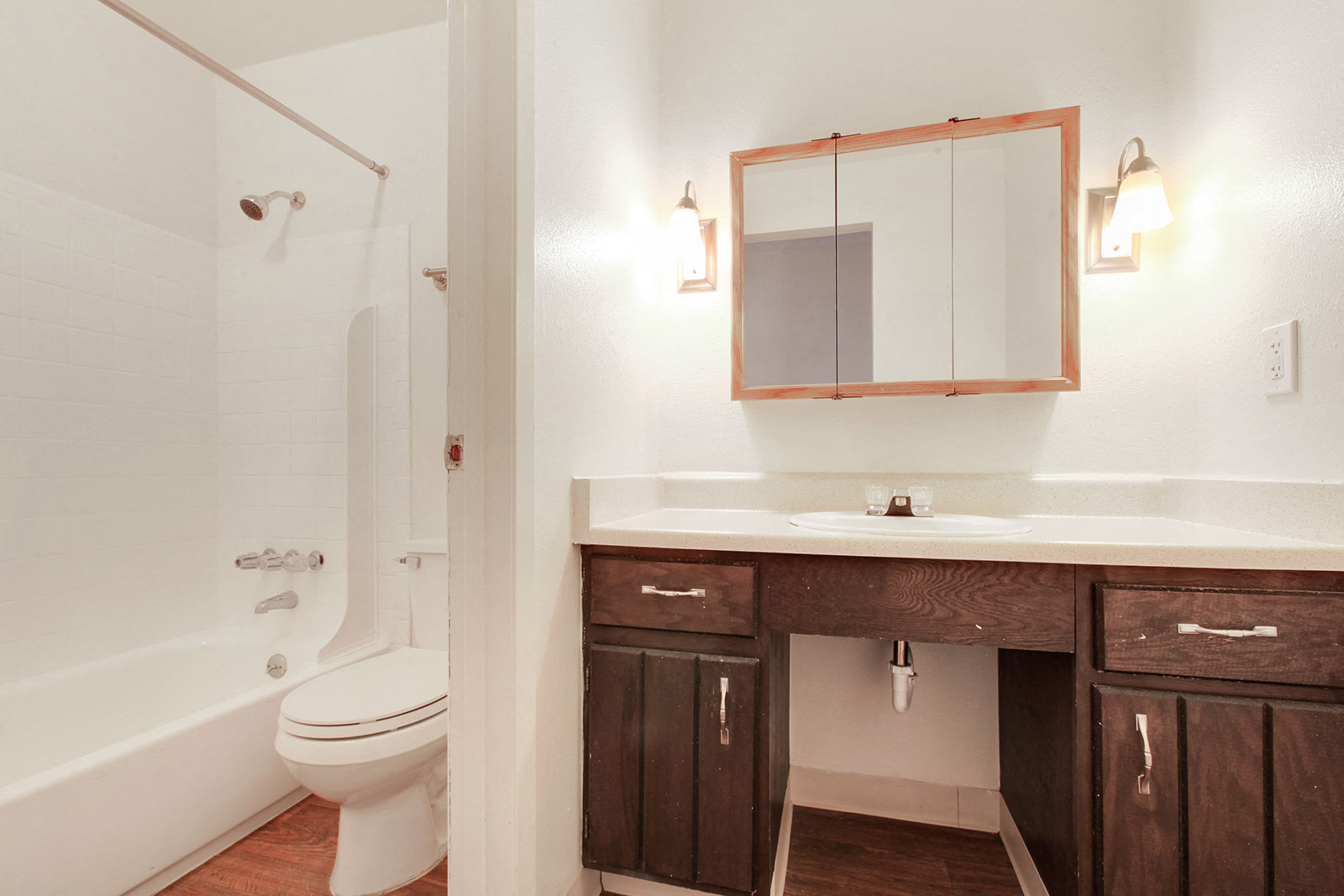 a bathroom with a toilet sink and shower and a mirror