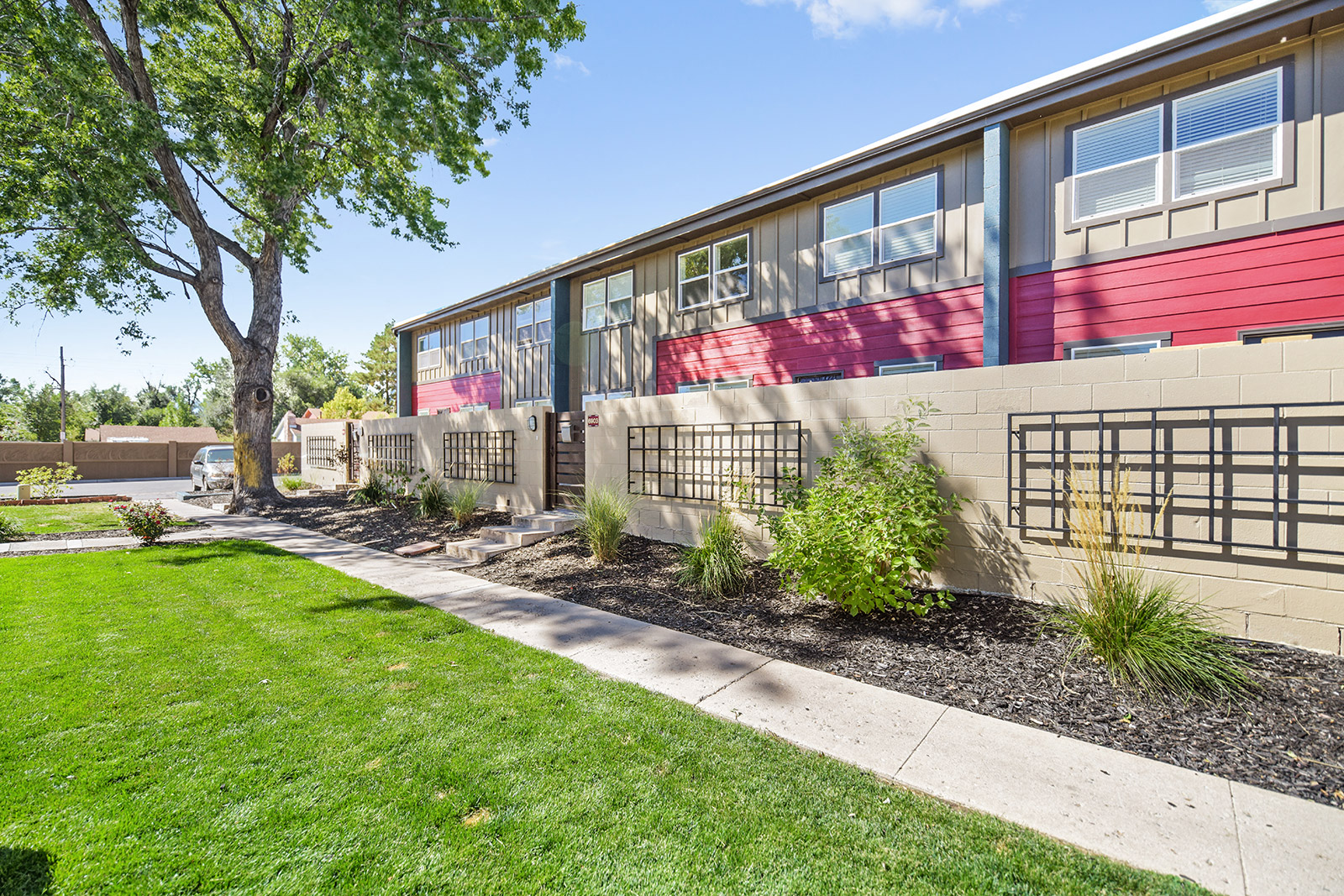 the front of a school building with a sidewalk and grass