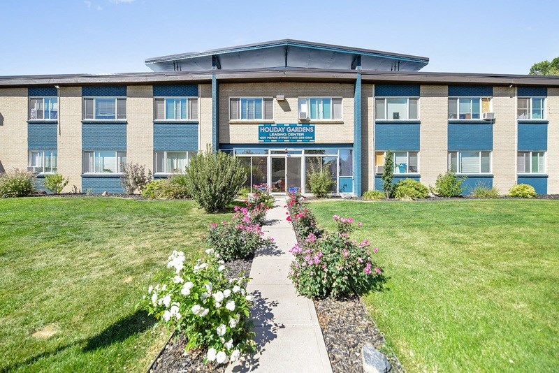 the front of a building with flowers in front of it