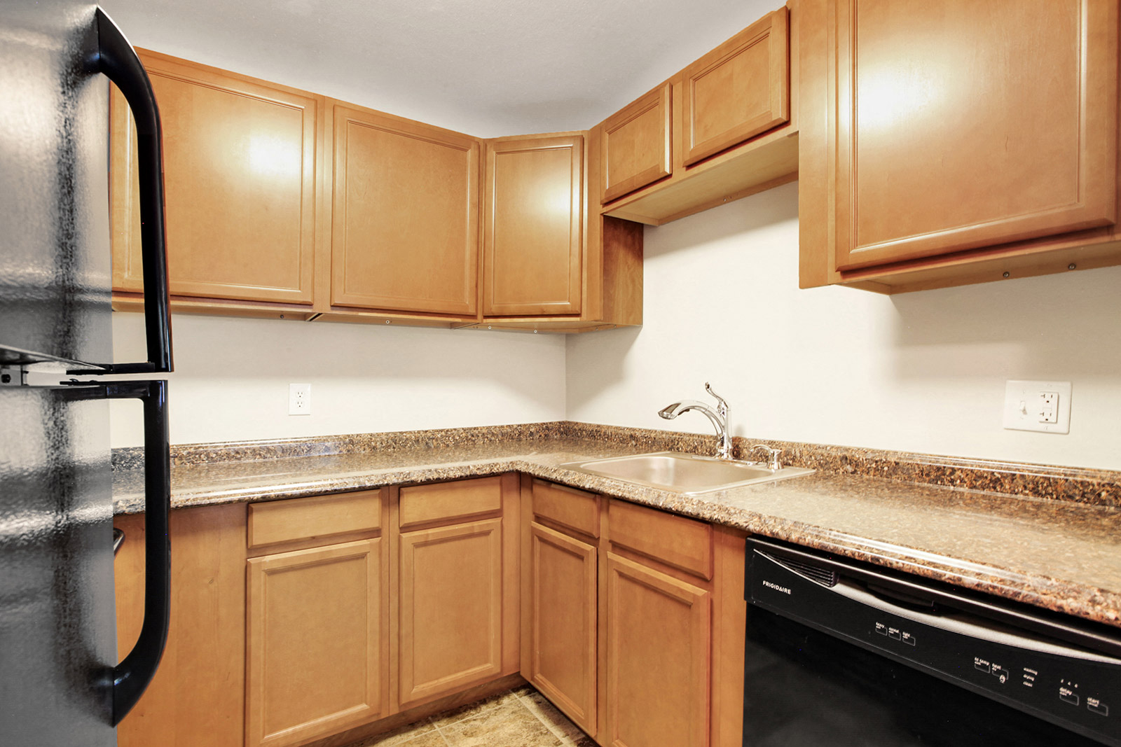 a kitchen with wood cabinets and granite counter tops and a sink