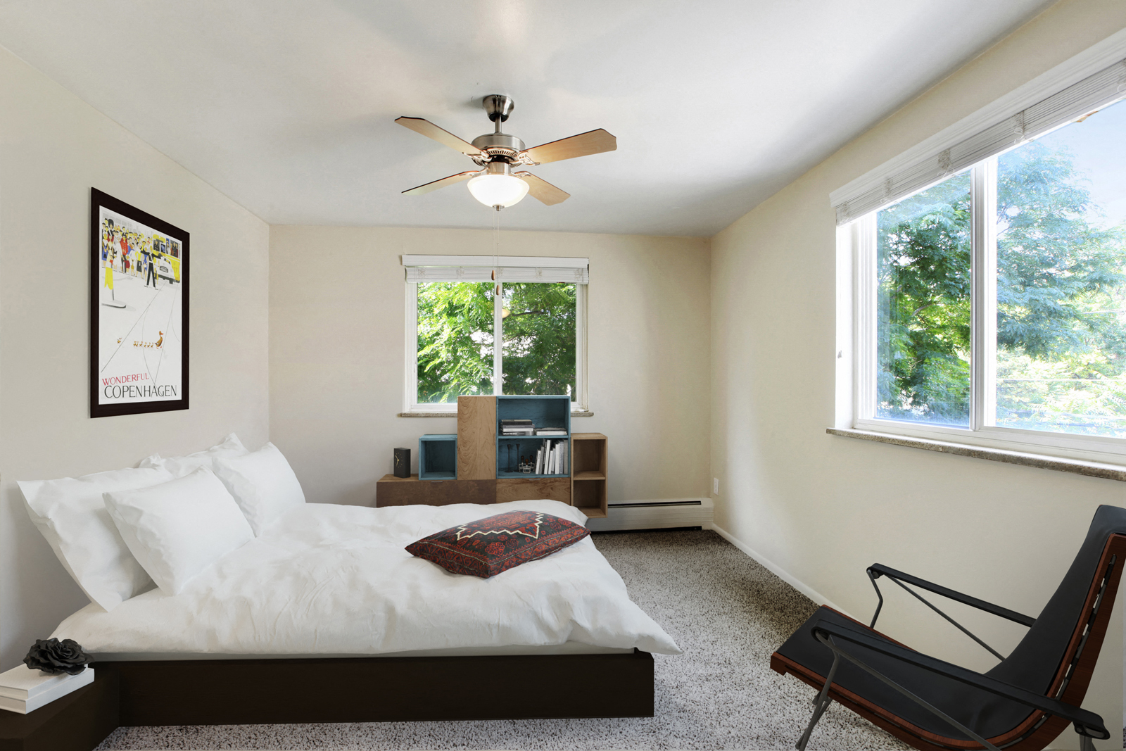 a bedroom with a bed and a ceiling fan and two windows