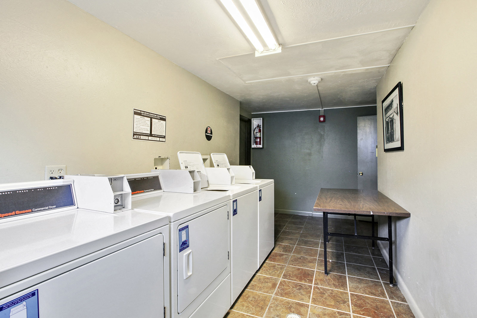 a laundry room with washers and dryers and a table