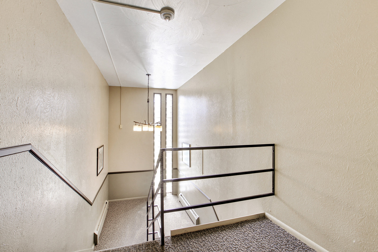 a stairwell in a building with white walls and metal railings