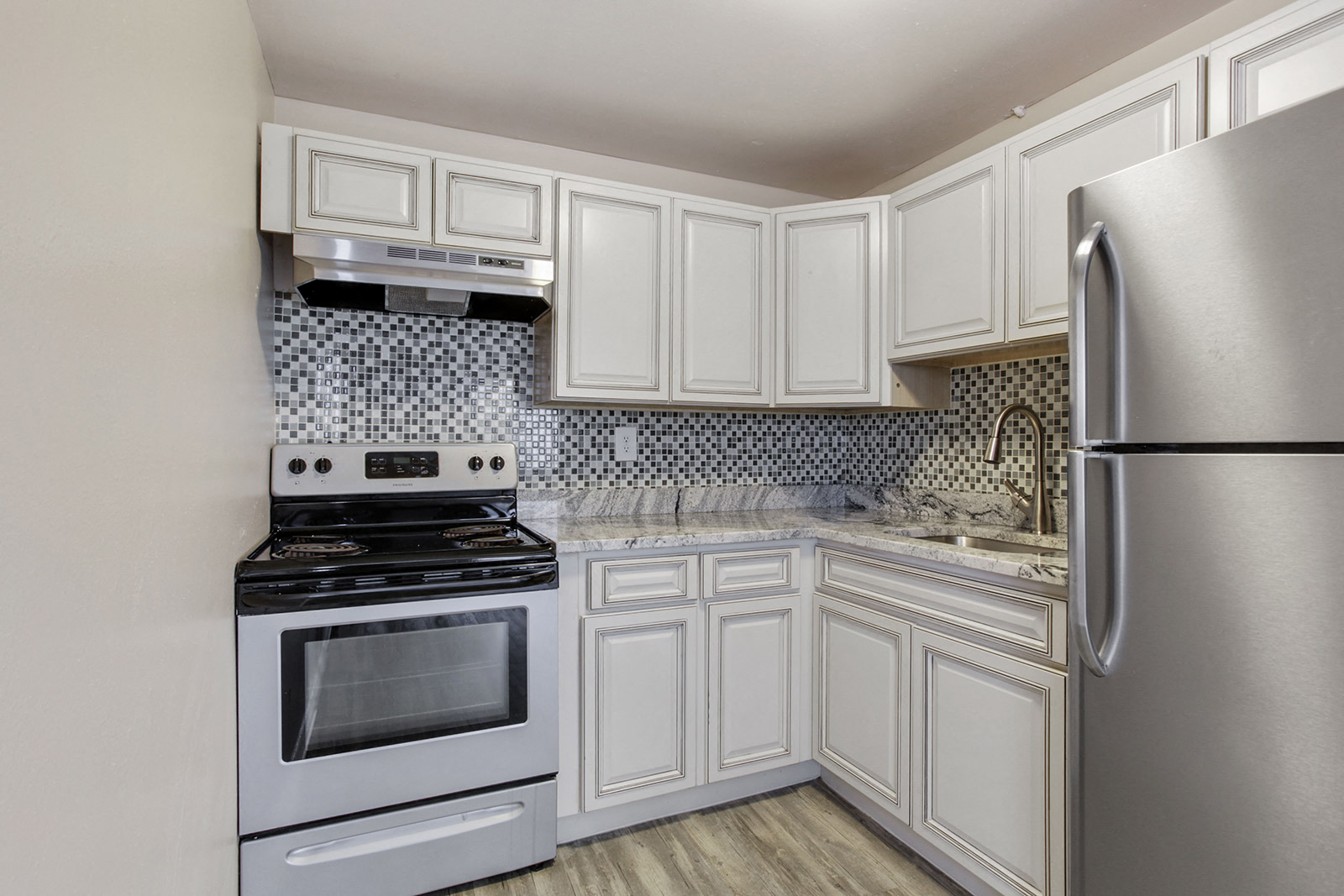 a white kitchen with stainless steel appliances and white cabinets