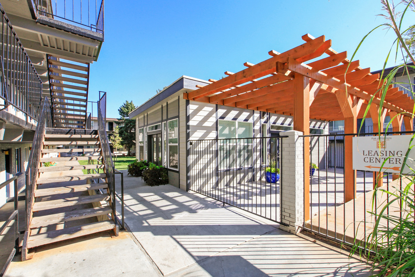 the entrance to leasing center with stairs and a gate to the building