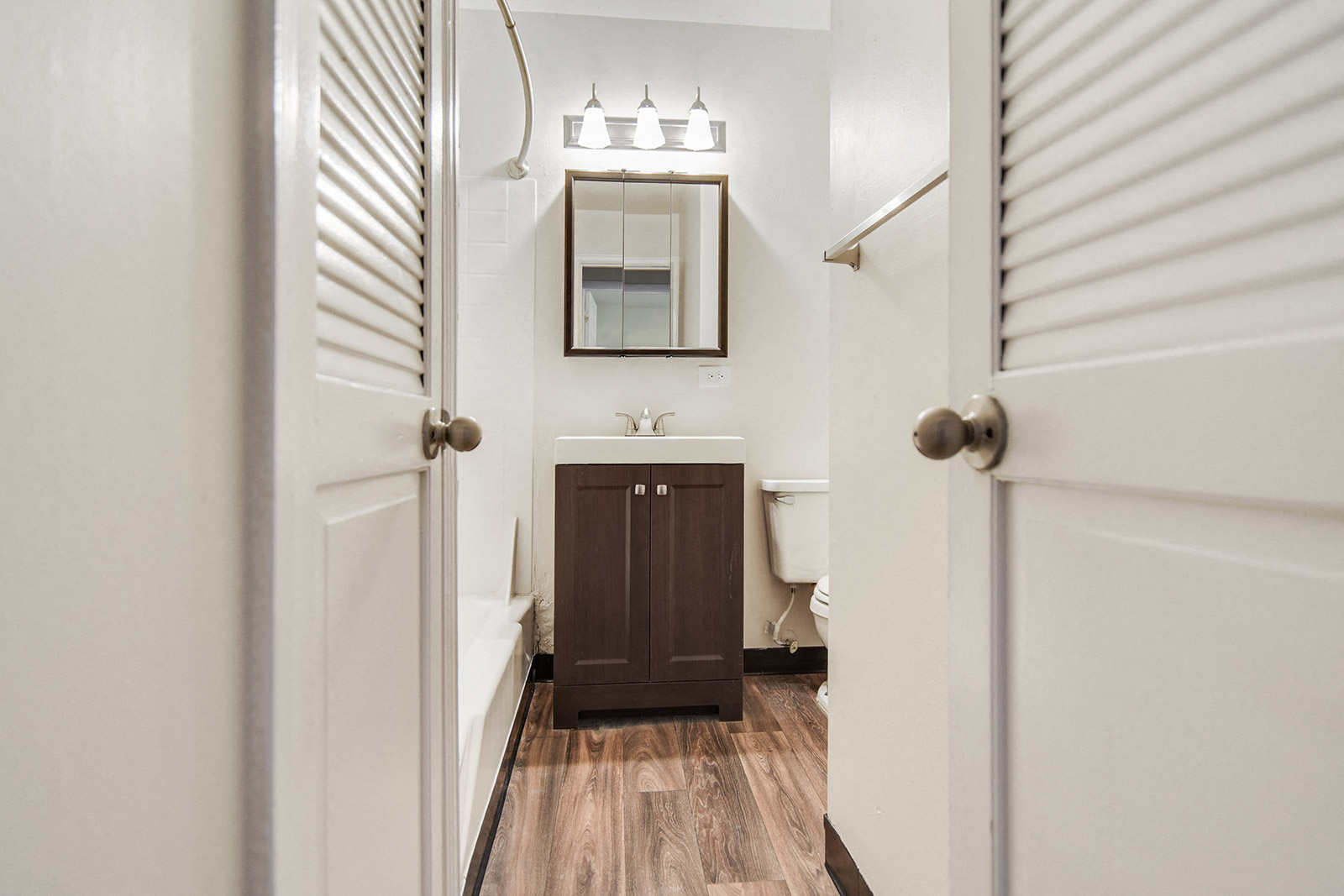 a bathroom with a sink and a mirror and a door