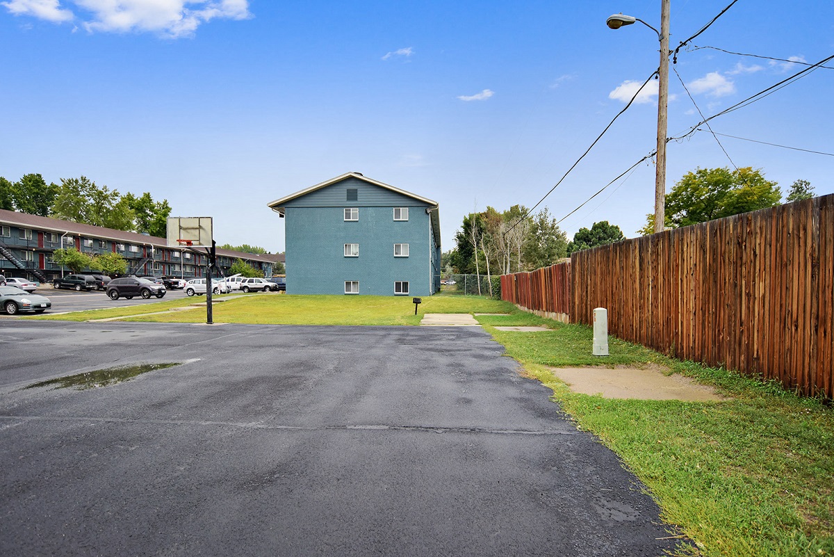 a street with a blue building and a wooden fence