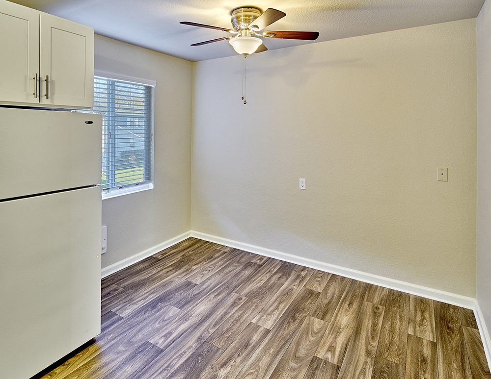 Dining area with ceiling fan, wood style flooring and window.at Woodhaven, Everett, 98203