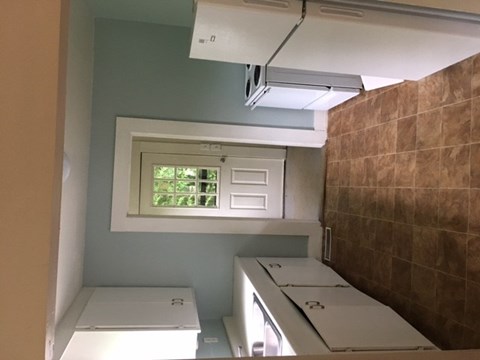 a small kitchen with white appliances and a window