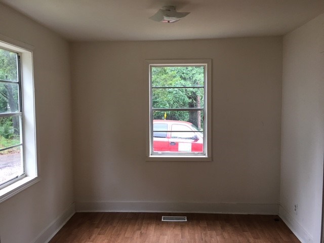 an empty room with a window and a red car in it