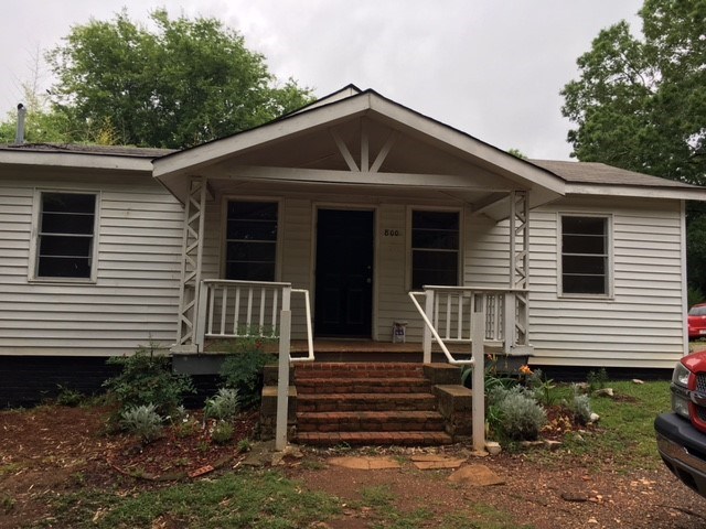 a white house with a porch and stairs