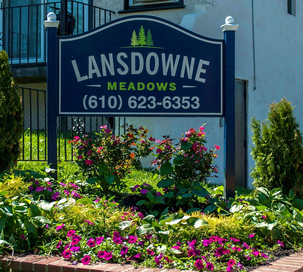 a sign for the lansdowne meadows neighborhood in front of a house