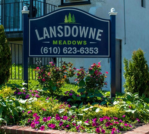 a sign for the lansdowne meadows neighborhood in front of a house