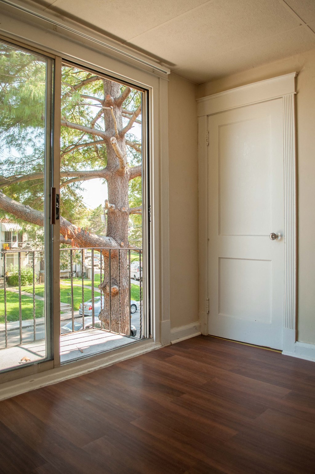 a living room with a door to a balcony and a tree