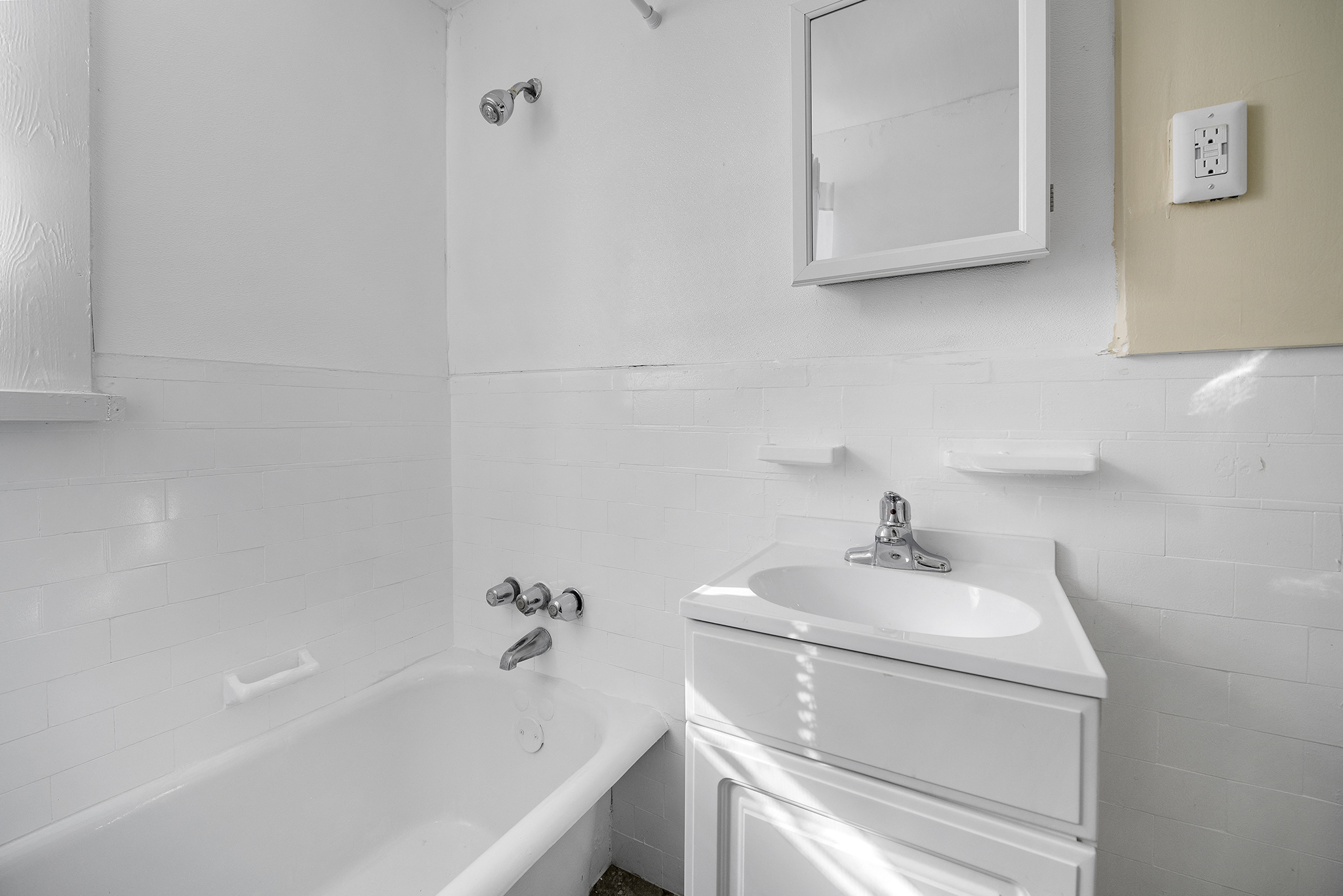 a bathroom with a sink and a bath tub and a mirror