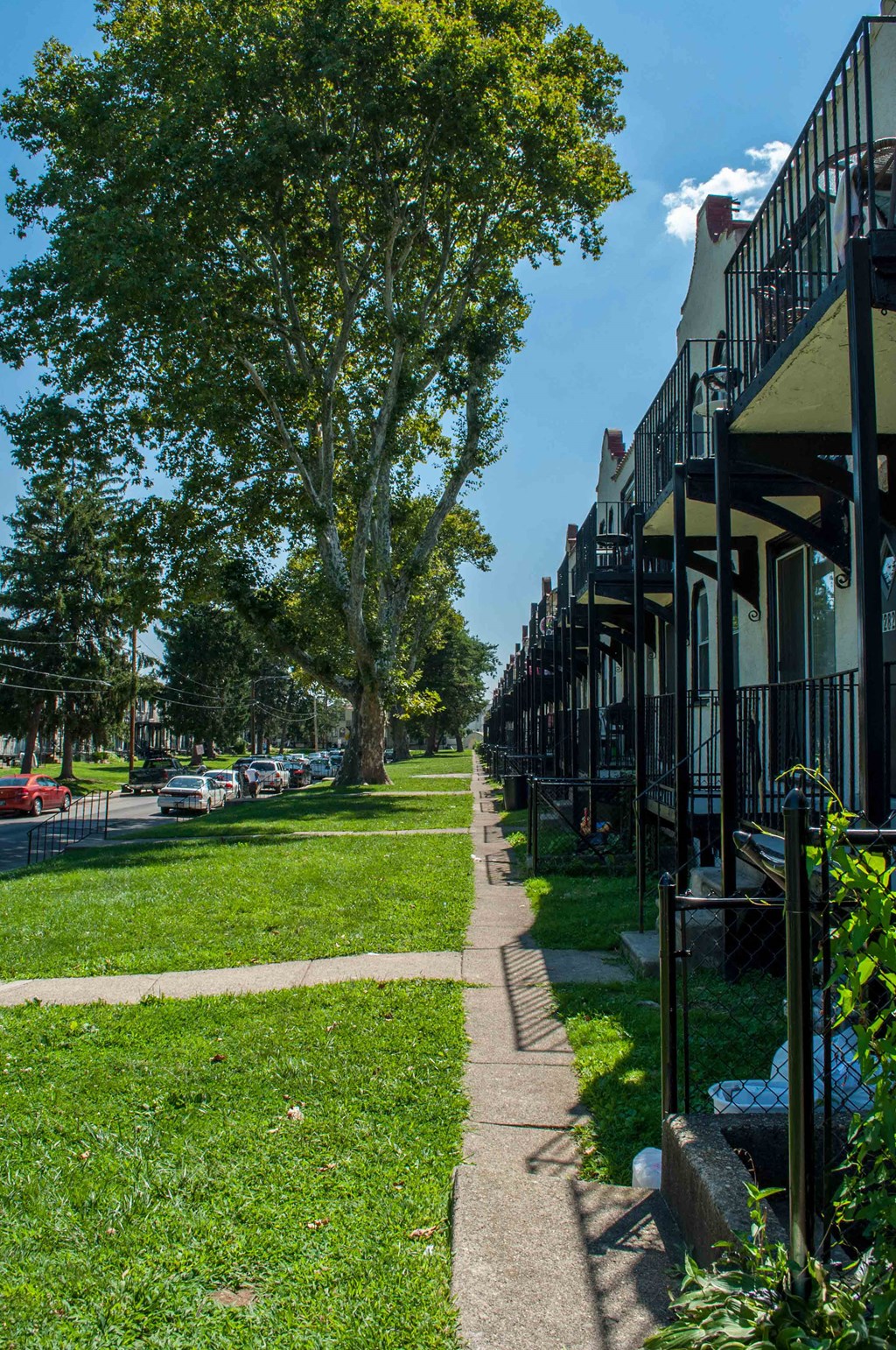 a row of houses on the side of a sidewalk