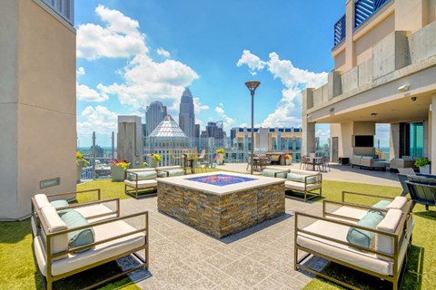 A patio with a pool table and chairs overlooking a city skyline.