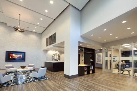 A modern living room with a white couch and a painting on the wall.