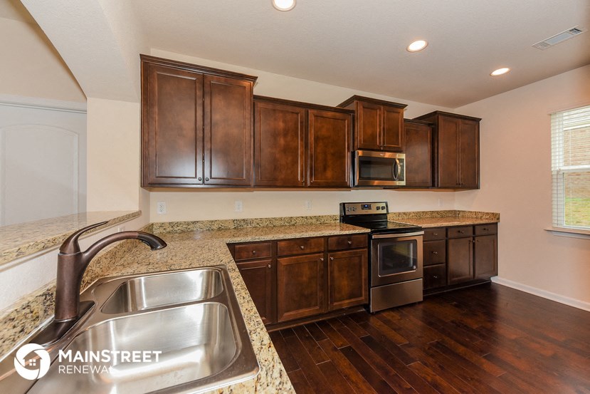 a kitchen with wooden cabinets and granite counter tops and a sink