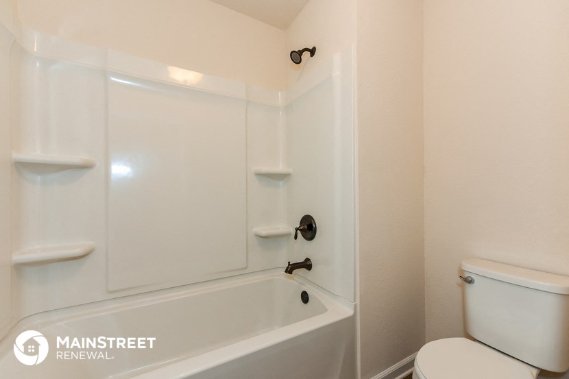 a white bathroom with a tub and a toilet