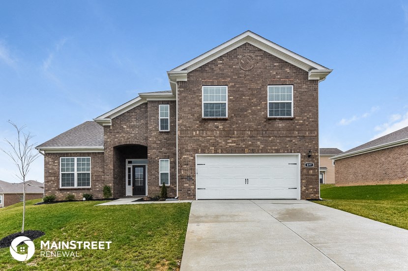 a brick house with a white garage door in front of it