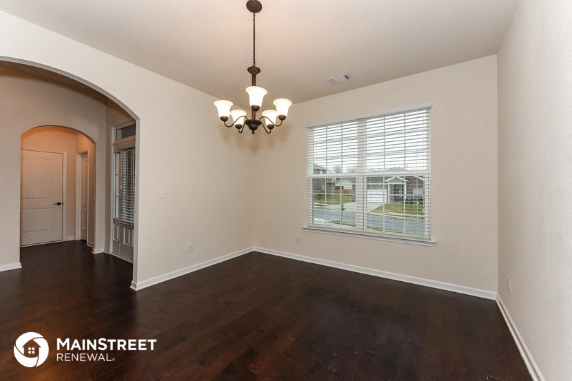 the living room and dining room of an empty house with a large window
