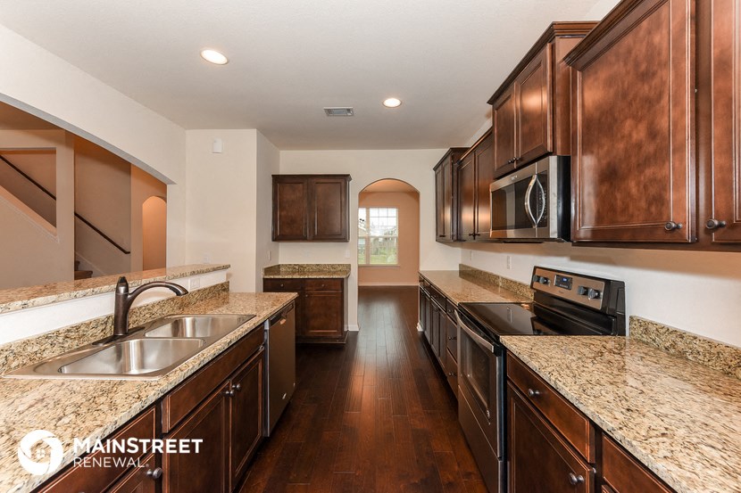 a large kitchen with granite counter tops and wooden cabinets