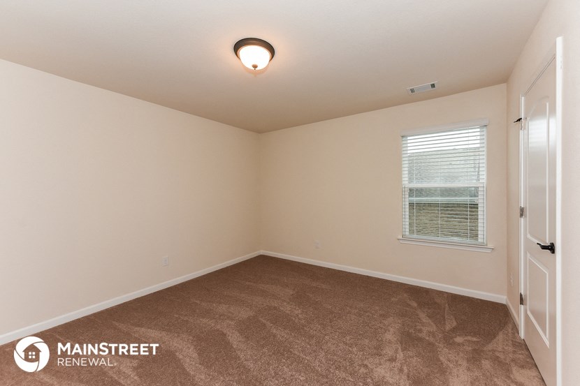 the upstairs bedroom with carpeted flooring and a window