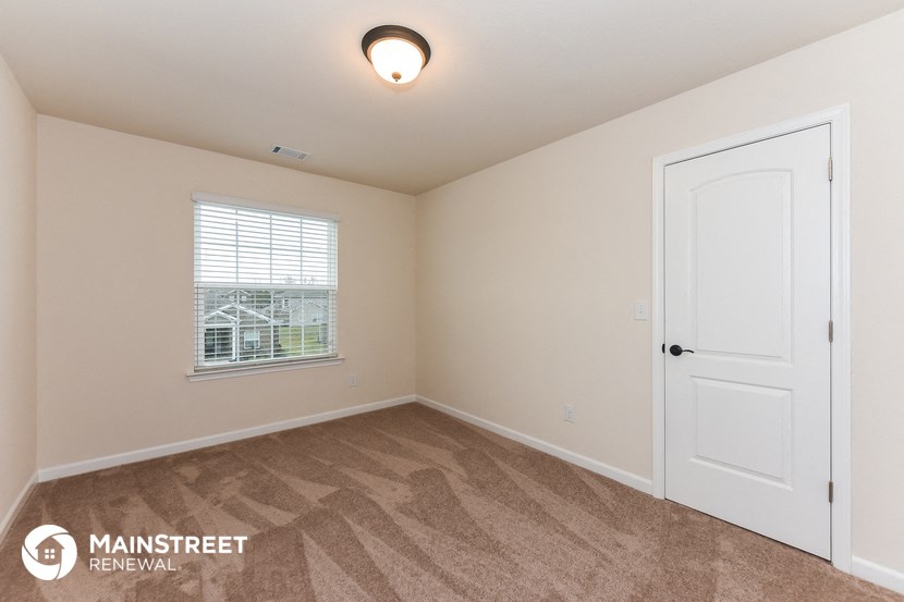 a bedroom with a white door and a window