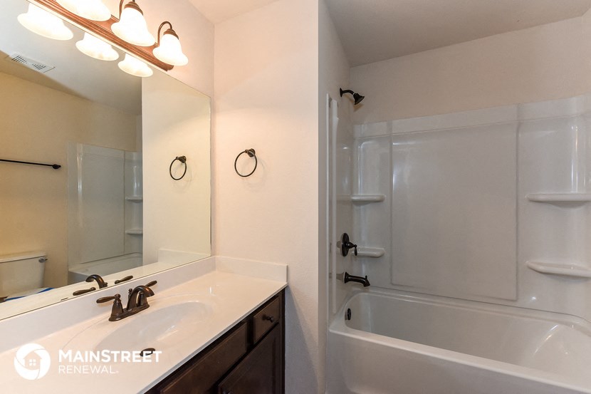 a bathroom with a sink and a tub and a mirror