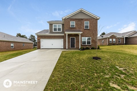 a brick house with a white garage door and a lawn