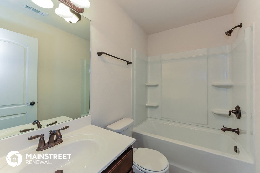 a bathroom with a sink and a tub and a mirror