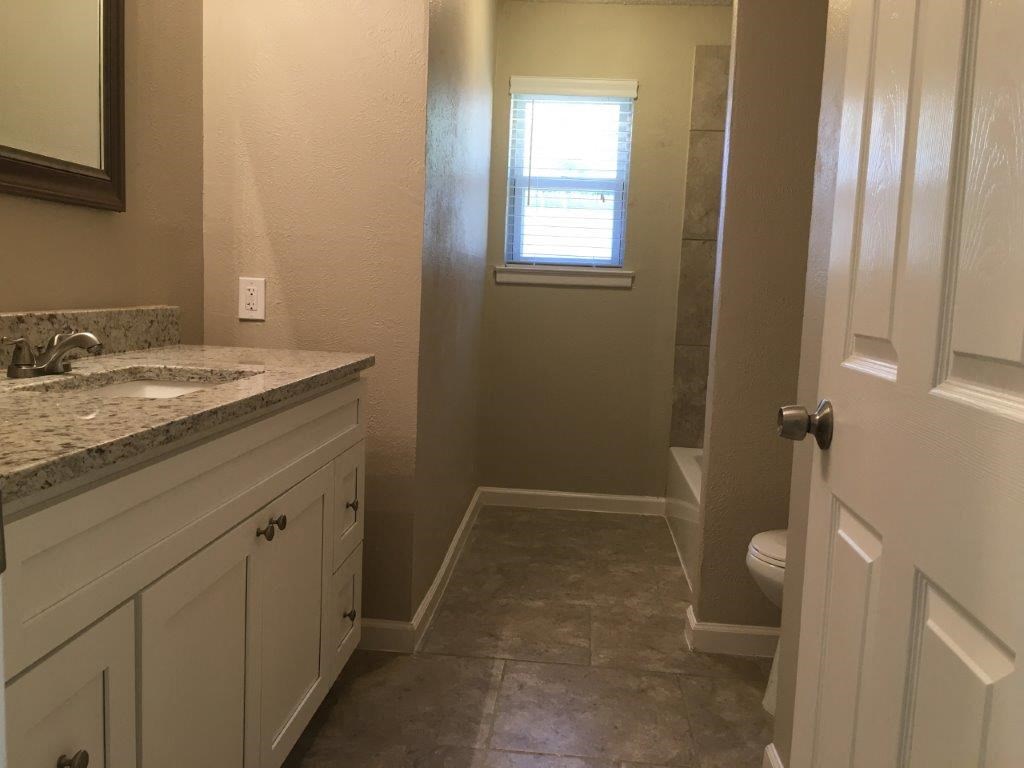 a bathroom with a sink and a toilet and a window