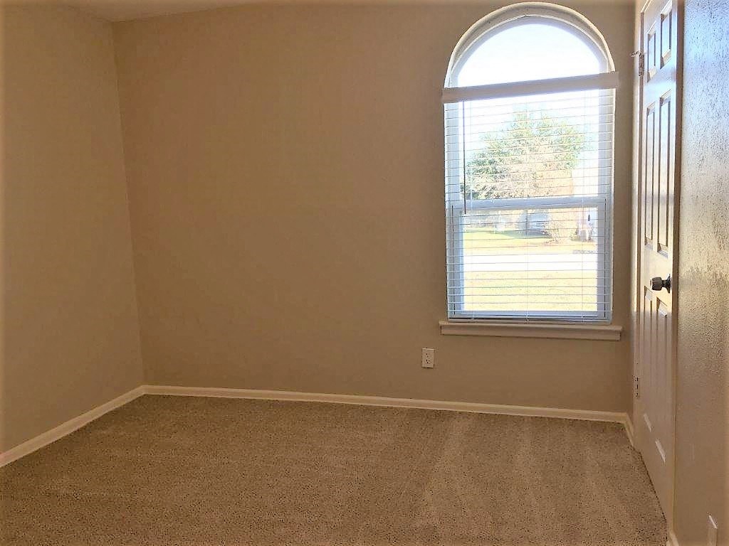 an empty room with a window and a door