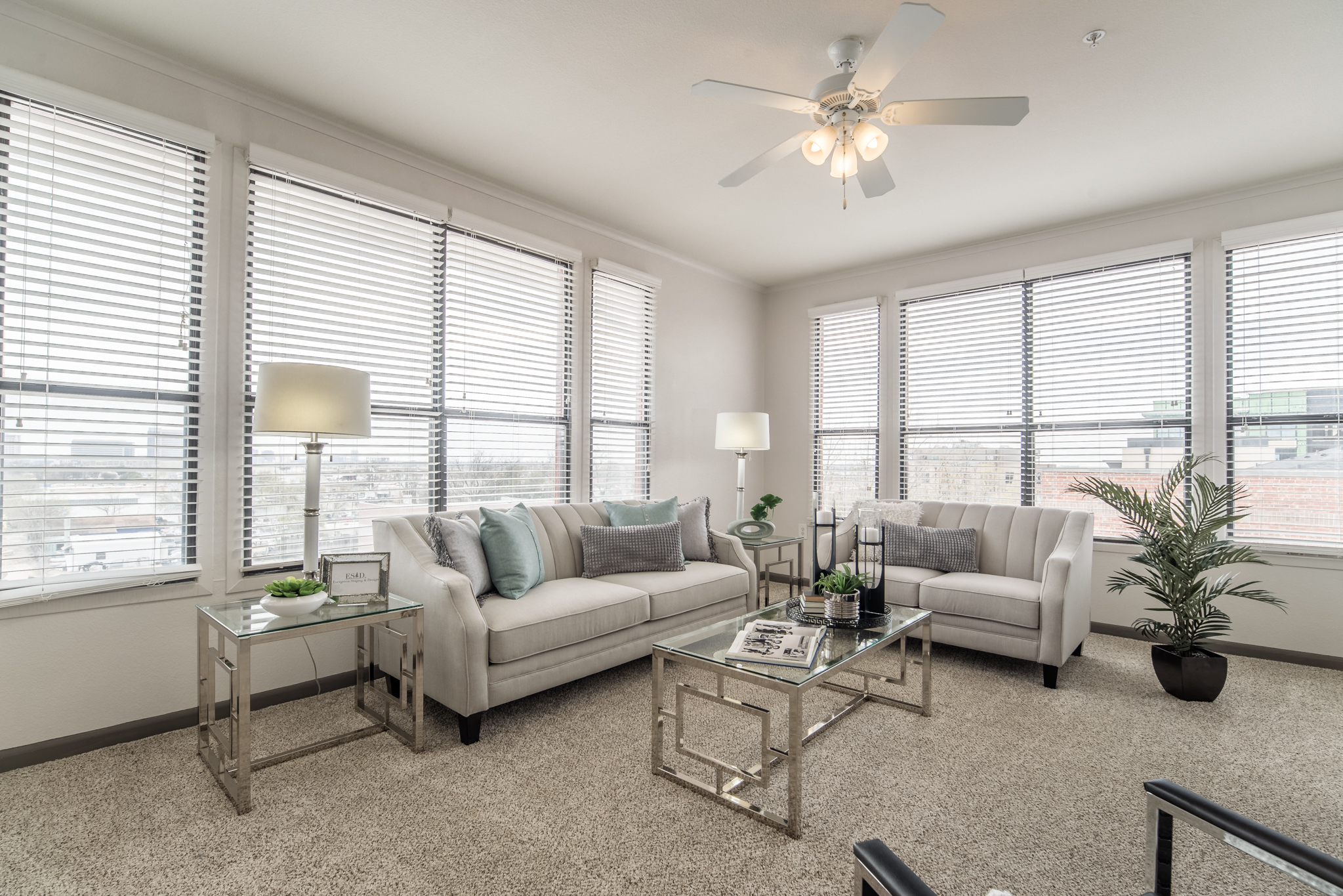 an open living room with a ceiling fan and windows