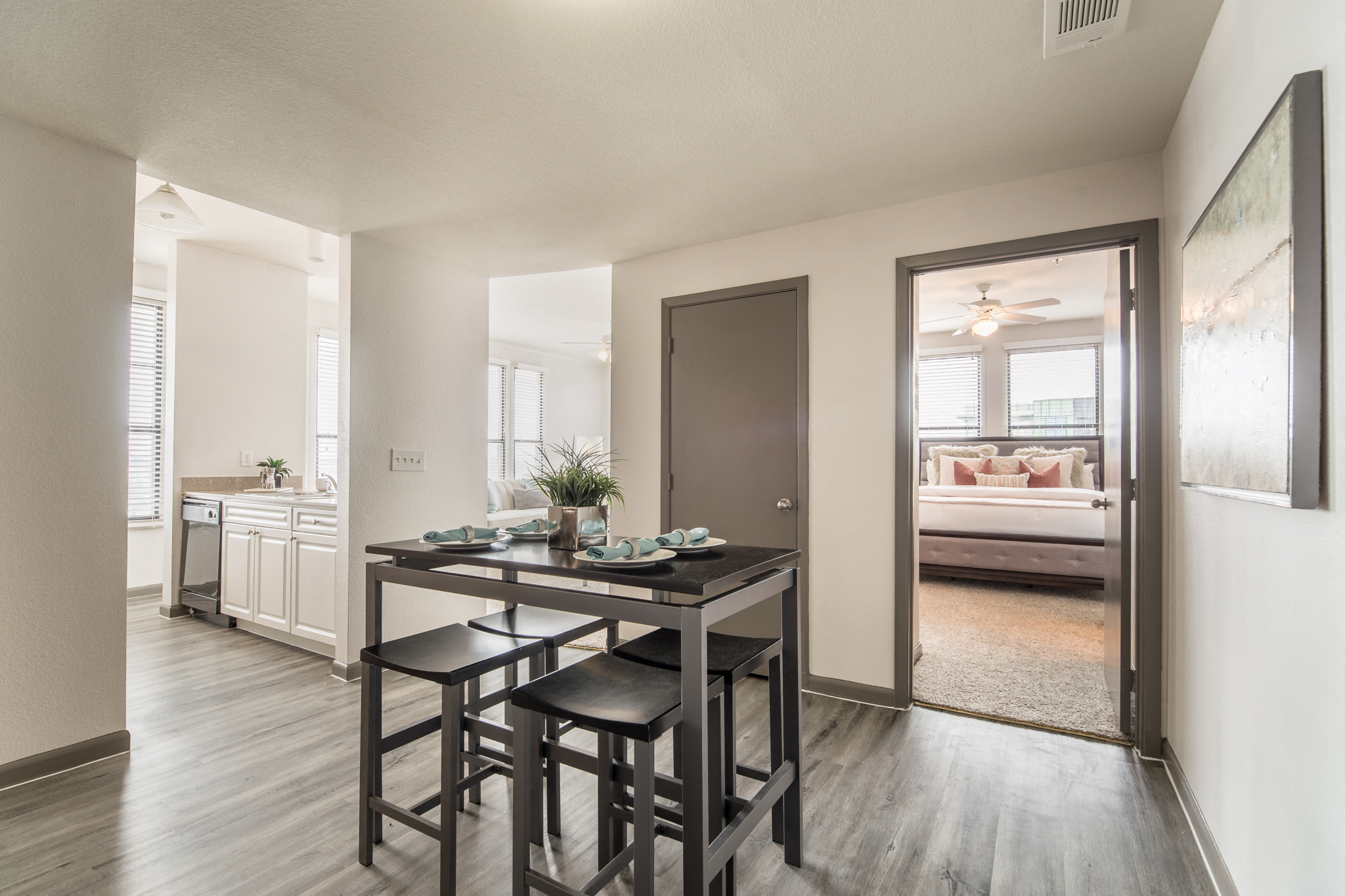 an open kitchen and living room with a dining table and stools